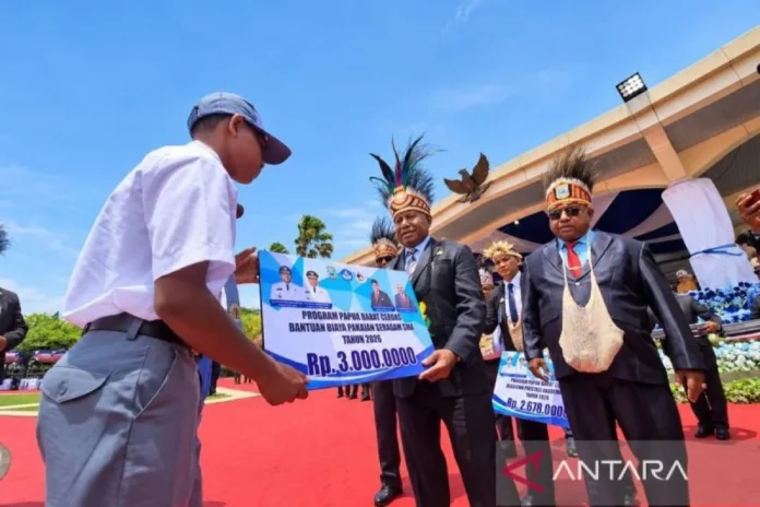 Gubernur Papua Barat Dominggus Mandacan menyerahkan bantuan seragam kepada siswa SMA